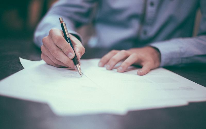 Person reviewing paperwork with a pen